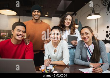 Multiracial group of five young people looking at camera smiling. Stock Photo