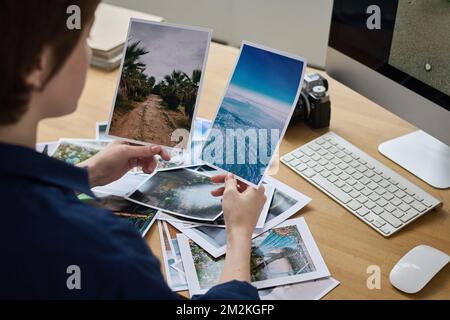 Young designer working with professional photos during work at her workplace with computer Stock Photo