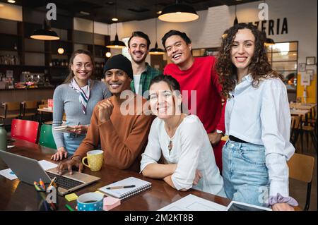 Young and succesfull mixed race people looking at camera. Teamwork or students cooperation. Stock Photo