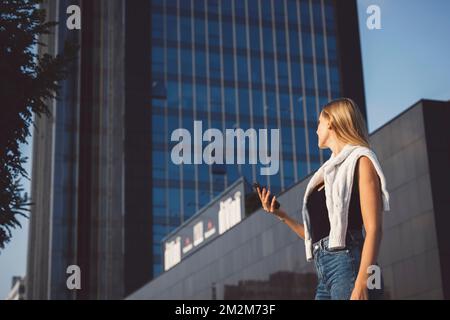 Young blonde woman in an urban setting using a mobile device Stock Photo