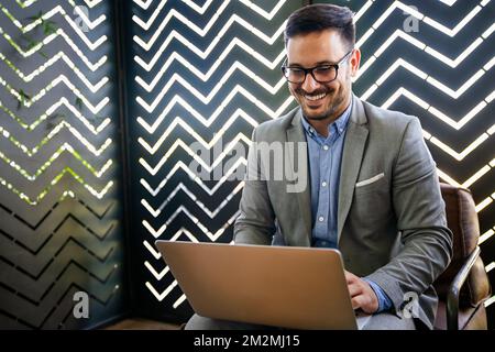 Portrait of young successful businessman with digital device working in corporate business office Stock Photo