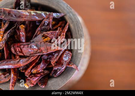 Top view closeup dry red chili peppers on brown wooden table. Dried red chili peppers closeup, traditional food ingredients. Macro raw Stock Photo