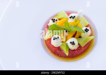 Tropical fruit salad with dragon fruit, watermelon and orange papaya on white elegant background. Healthy diet, breakfast in luxury resort hotel Stock Photo