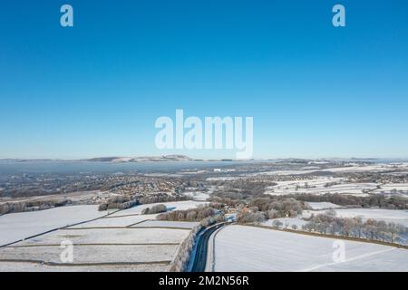 Aerial drone photo of the town of Mereclough in the town of Burnley in Lancashire, England showing the farmers fields on a snowy winters day in the UK Stock Photo