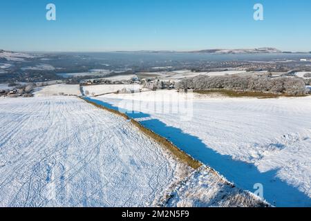 Aerial drone photo of the town of Mereclough in the town of Burnley in Lancashire, England showing the farmers fields on a snowy winters day in the UK Stock Photo