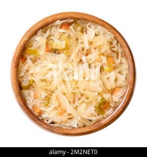 Bavarian style sauerkraut, in a wooden bowl. German sauerkraut, a warm served side dish, made of fermented cabbage, cooked with carrots, leek and beer. Stock Photo