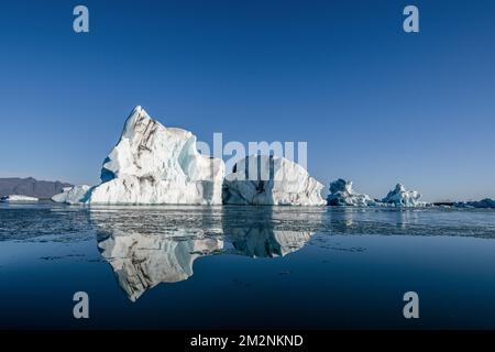 General view of Icebergs visible floating on the waters of Lake Jökulsárlón. Jökulsárlón is a lake located in southern Iceland, with an area of 20 km2 and a depth of over 200 meters. Until less than 100 years ago, the Breiðamerkurjökull glacier (part of the Vatnajökull glacier) extended even beyond the ring road. Due to rising temperatures, the glacier has retreated, creating this impressive glacial lagoon. Stock Photo