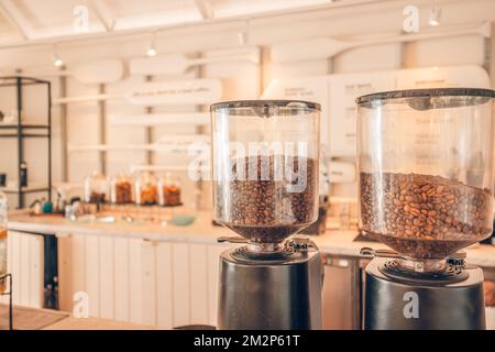 Closeup coffee beans with modern blur coffee shop interior background. Morning sunlight, start the day with positive vibes, happy moods Stock Photo