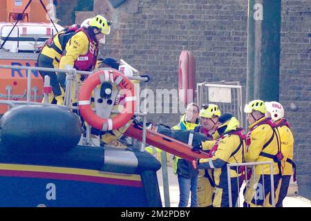 Members of the RNLI remove a stretcher and body bag from the Dover lifeboat after it returned to the Port of Dover following a large search and rescue operation launched in the Channel off the coast of Dungeness, in Kent, during an incident involving a small boat likely to have been carrying migrants. Three people have died following the incident and 43 people have been rescued, a Government source said. Picture date: Wednesday December 14, 2022. Stock Photo