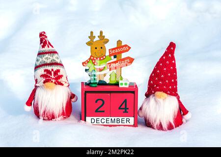 Cube calendar with date 24 December, Scandinavian gnomes and Christmas decor in snowy forest Xmas holiday card Christmas date. Stock Photo