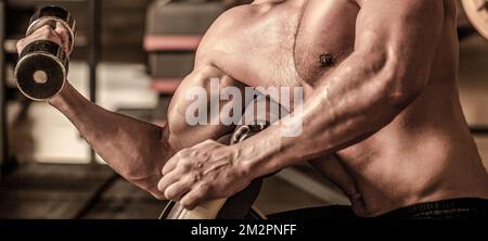 Man bodybuilder doing exercises with dumbbells. Fitness man lifting dumbbell Stock Photo