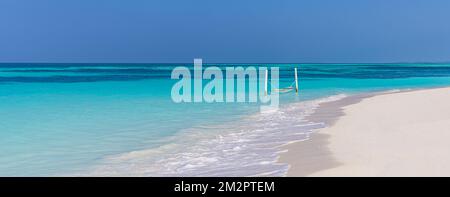 Luxury beach. Tranquil travel background. Summer vacation or holiday concept on tropical beach white sand and amazing over water hammock over blue bay Stock Photo