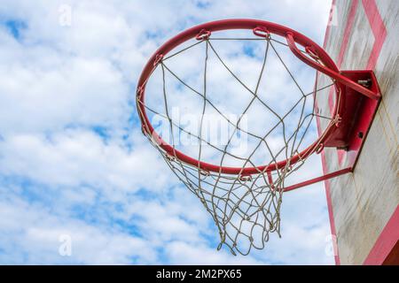 A basketball ring at the background of the sky with clouds. Side view. Stock Photo