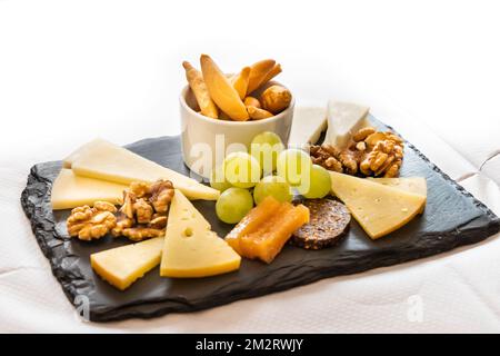 Platter of cheese, cracker, nuts and grapes served on cheeseboard Stock Photo