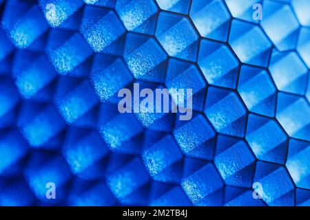 Abstract geometric background of hexagonal cells with blue highlights and shallow depth of field Stock Photo