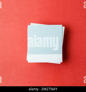 Blank paper note for your text or message on red background, top view. Stock Photo
