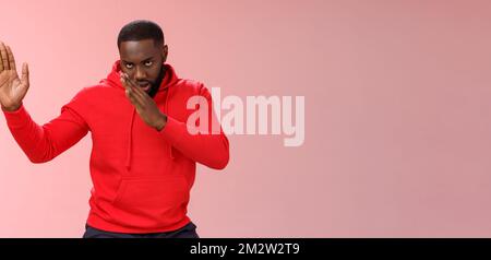 Guy knows asian fighting skills. Portrait serious-looking funny african-american young man perform martial arts standing kung-fu karate pose raised Stock Photo