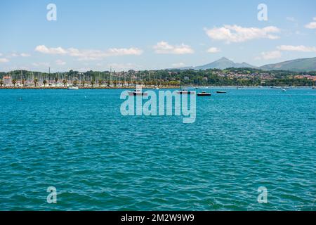 View over the sea with a city and mountains in the background Stock Photo