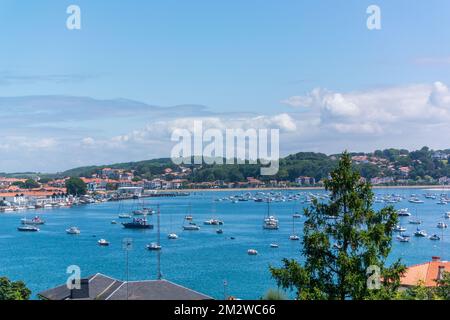 View over the sea with a city and mountains in the background Stock Photo