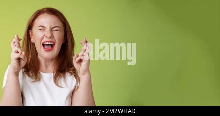Woman implore god protection. Close eyes yelling thrilled cross fingers ...