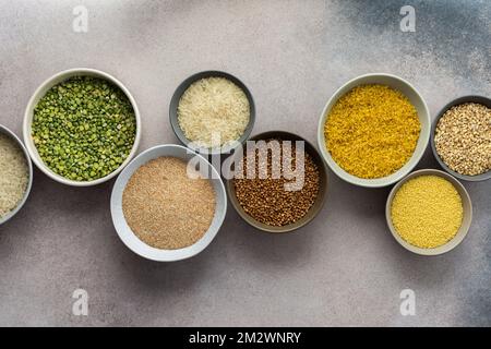 Various grain cereals in bowls on a light background, top view Stock Photo