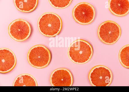 grapefruit slices on pink background Stock Photo