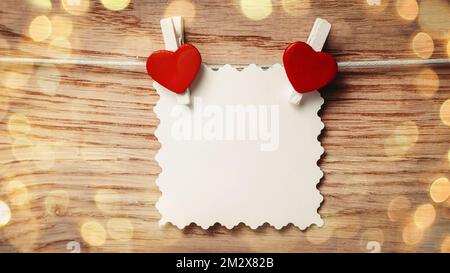 sheet form with hearts attached to a rope. beautiful bokeh effect from a garland. Stock Photo