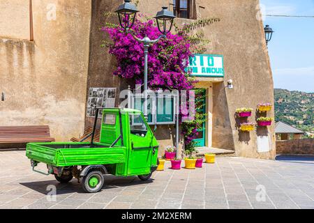 Green Piaggio Ape utility vehicle in front of the cathedral of Rio nell Elba, Elba, Tuscan Archipelago, Tuscany, Italy Stock Photo