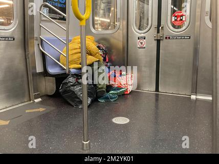 Homeless man asleep on a subway train in New York on Wednesday, December 7, 2022. (© Frances M. Roberts) Stock Photo