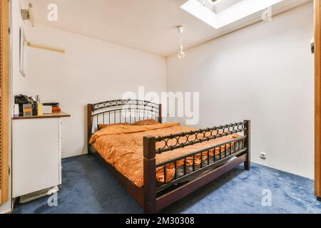 a bedroom with a bed, refrigerator and microwave on the wall in front of the room that has been used for several years Stock Photo