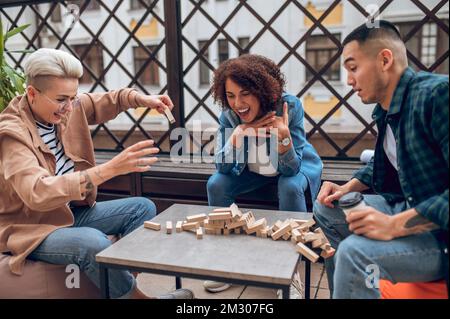 Young adults participating in a board game on the veranda Stock Photo