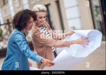 Design professionals busy analyzing a site development plan Stock Photo