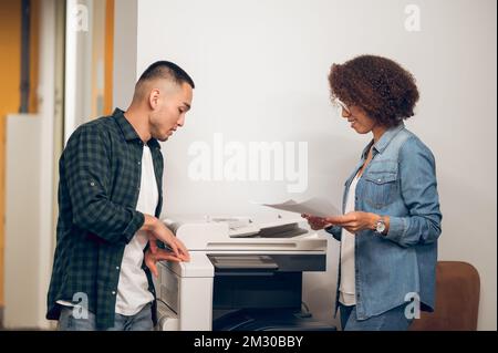 Assistant making document copies for her boss using the photocopier Stock Photo