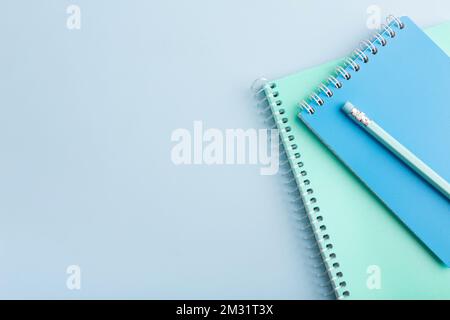 Blue notepad and pencil on a blue background. Place for your text. High quality photo Stock Photo