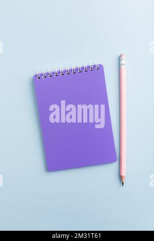 Purple notebook on a blue background with a pencil. High quality photo Stock Photo