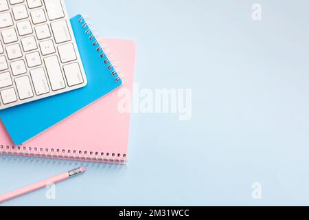 Pink and blue notepad and pencil on a blue background. Place for your text. High quality photo Stock Photo