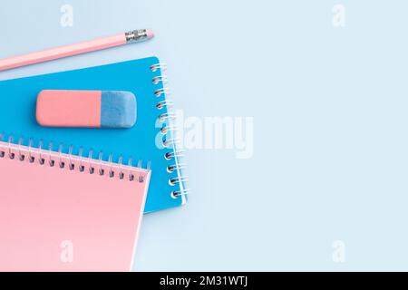 Pink and blue notepad and pencil on a blue background. Place for your text. High quality photo Stock Photo
