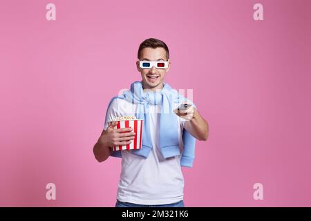 man using remote and holding a big bucket of popcorns Stock Photo
