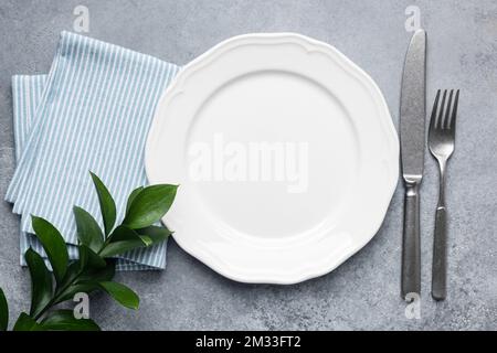 White plate with silverware and napkin. Table setting, elegant dining plate. Top view, copy space Stock Photo