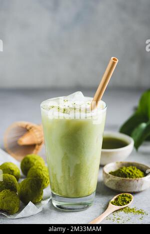Cold Matcha Latte Ice In Glass With Bamboo Drinking Straw. Healthy Vegan Drink, Coffee Alternative. Copy Space Stock Photo