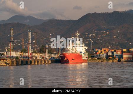 Red tanker ship at terminal port. Transportation, logistics and unloading of gas or oil in industrial harbor. Stock Photo