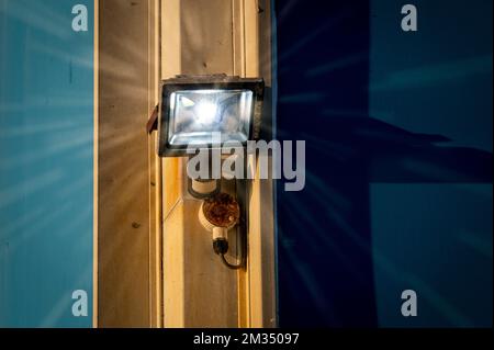 Illuminated security light on the side of a building. Stock Photo