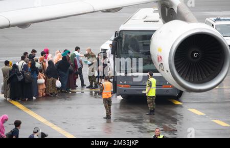 People disembark at the arrival of a chartered Air Belgium airplane carrying evacuated people from Afghanistan, at the military airport in Melsbroek, Monday 23 August 2021. The Belgian military evacuation mission 'Operation Red Kite' flies defense cargo planes back and forth between the Pakistani capital Islamabad and Kabul in Afghanistan, to get Belgians and their families, but also Afghans such as interpreters, fixers and employees of human rights organizations safely out of Afghanistan. BELGA PHOTO BENOIT DOPPAGNE Stock Photo
