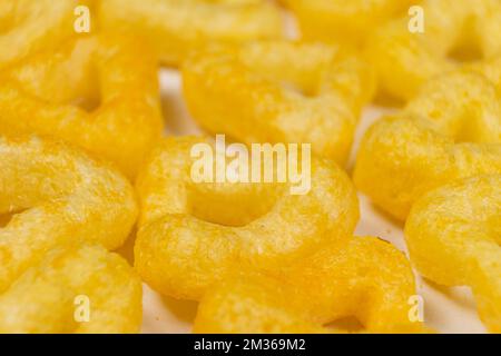 Delicious crispy corn chips triangular shape with spices, macro. Stock Photo