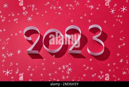 numbers two zero two three and snowflakes on red background Stock Photo