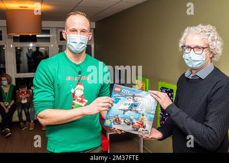 Vincent Andries, Brand Manager LEGO hands a box of Lego to Wim Van de Waeter (general manager patient care ZNA) ahead of a sound and vision show with drones at the 'ZNA Koningin Paola Kinderziekenhuis' children's hospital in Antwerp, organized by the Lego toy manufacturer on Tuesday 28 December 2021. BELGA PHOTO JONAS ROOSENS Stock Photo