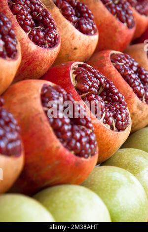 Open pomegranates apples oranges at street market. Fruits counter fresh juice. Stock Photo