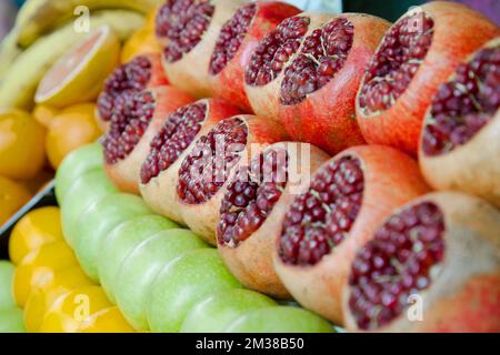 Open pomegranates apples oranges at street market. Fruits counter fresh juice. Stock Photo