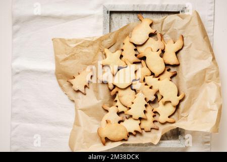 Pile of Christmas-themed gingerbread cookies on baking paper. Stock Photo