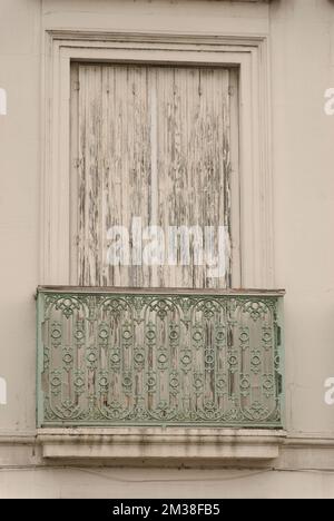 weathered old window with closed shutter and railing Stock Photo